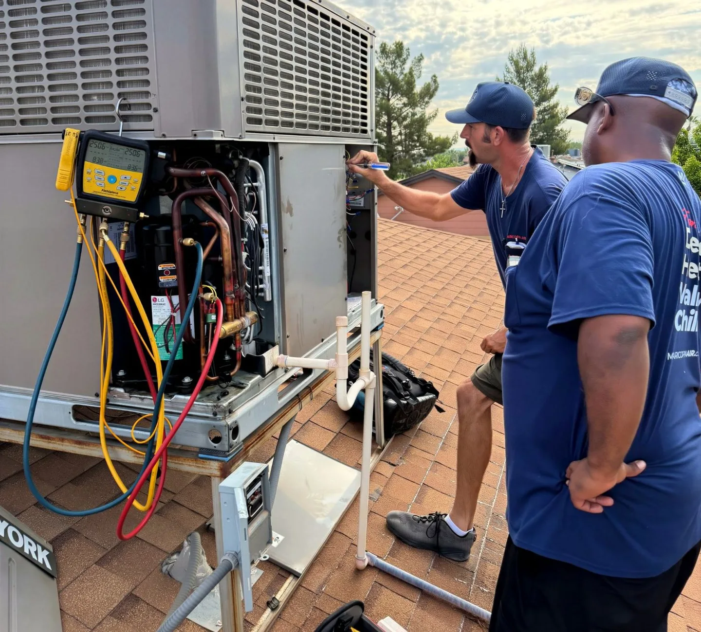 Maricopa Air technicians diagnosing a rooftop AC unit with refrigerant gauges in Scottsdale